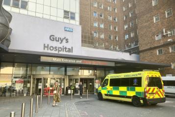 Exterior of Guy's Hospital with an ambulance out front.